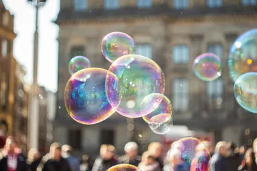 A close up of some bubbles in a town square which is our of focus behind.