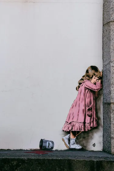 A picture on a wall of a child looking scared.