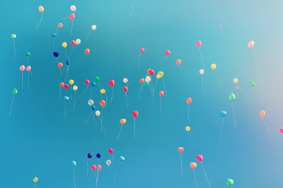 A clear blue sky filled with balloons