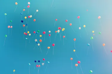 A clear blue sky filled with balloons