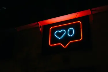 A red neon sign with a love heart and a zero
