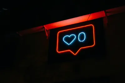 A red neon sign with a love heart and a zero